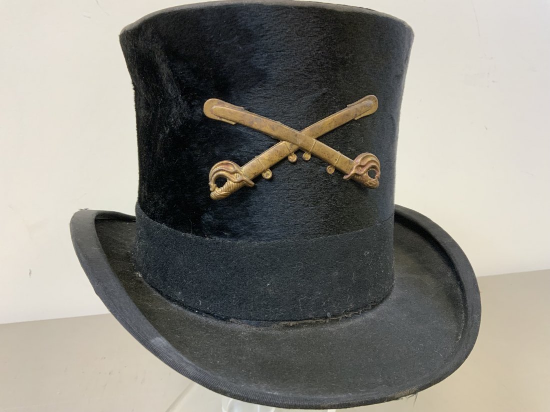ANTIQUE TOP HAT WITH US CAVALRY INSIGNIA: ANTIQUE TOP HAT WITH US CAVALRY INSIGNIA . LONDON ENGLAND MADE BEAVER TOP HAT AND SOLD BY NEW YORK CITY SHOP . US 19th CENTURY CAVALRY BRASS CROSSED SABRES INSIGNIA ATTACHED TO THE FRONT.
