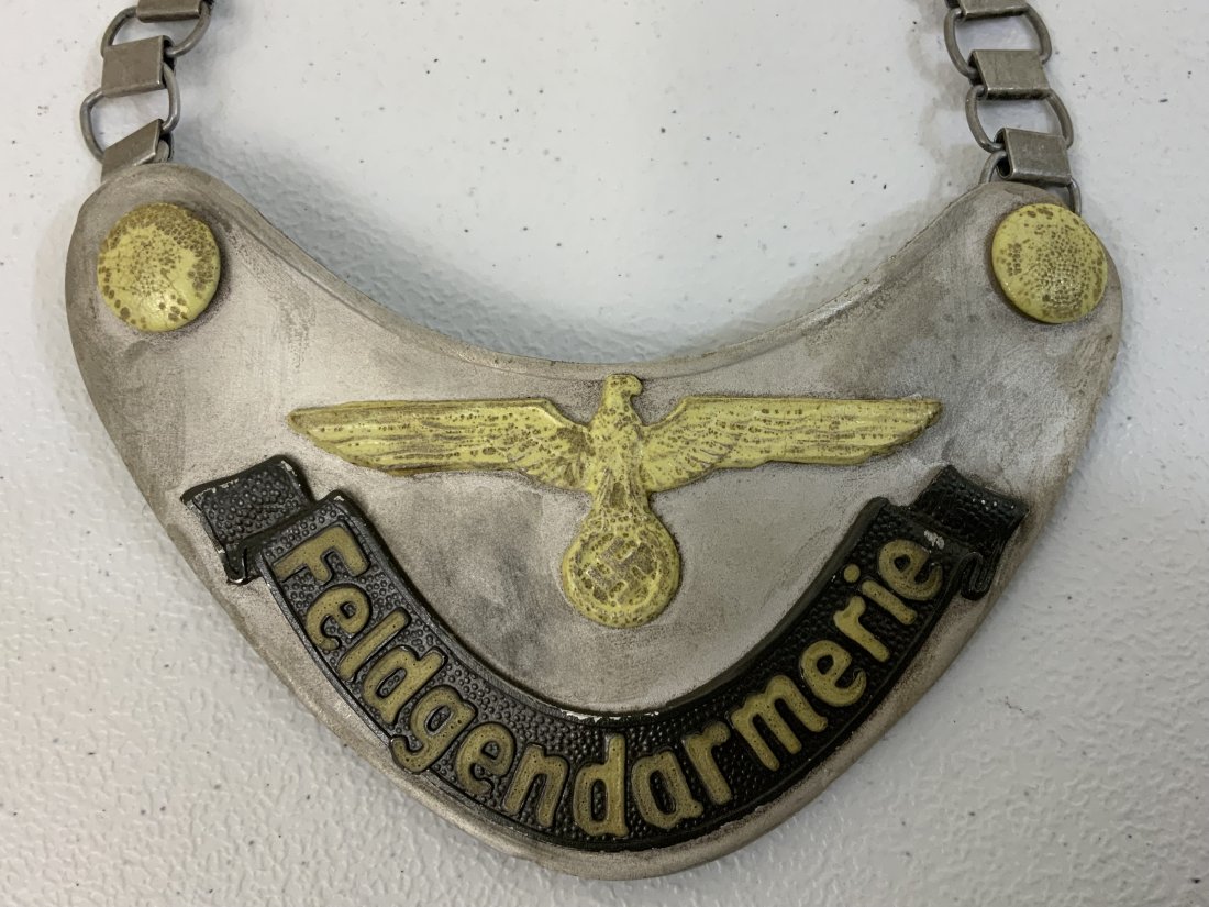 WWII GERMAN ARMY FELDGENDARMERIE FIELD POLICE GORGET WITH CHAIN: WWII GERMAN ARMY FELDGENDARMERIE FIELD POLICE GORGET WITH CHAIN . GREAT CONDITION. DARK FELT MATERIAL BACKING . MARKED D.R.G.M. LUMINOUS PAINT TO THE ARMY EAGLE , BUTTONS AND LETTERING. ALUMINUM TYPE.