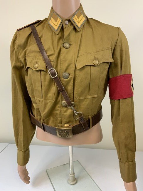NAZI GERMANY SA STORM TROOPER BROWN SHIRT UNIFORM WITH BELT: NAZI GERMANY SA STORM TROOPER BROWN SHIRT UNIFORM WITH BELT . GREAT CONDITION . RZM TAG INSIDE. EARLY ARMBAND. NICE BROWN LEATHER BELT WITH CROSS STRAP AND BRASS BUCKLE. GREAT DISPLAY UNIFORM .