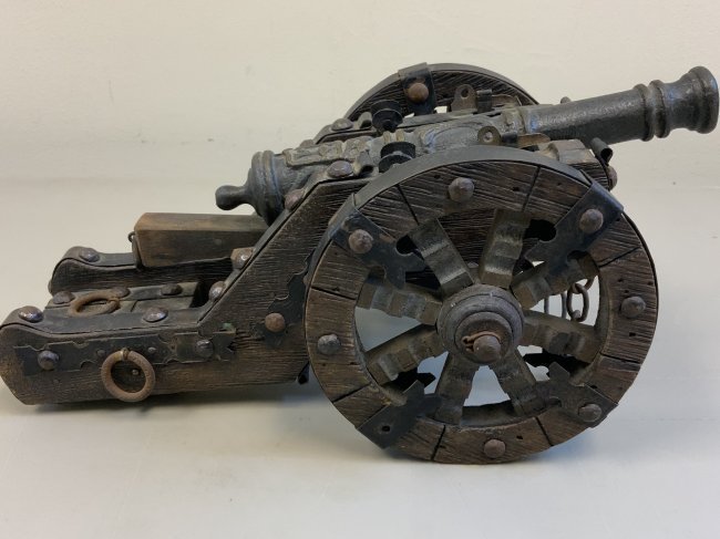 ANTIQUE MODEL OF A BRASS CANNON WITH WOODEN WHEELS: ANTIQUE MODEL OF A BRASS CANNON WITH WOODEN WHEELED MOUNT. VERY HIGH QUALITY MADE WITH THE ATTENTION TO ALL TINY DETAILS. BRONZE CANNON. WOOD AND METAL MOUNT. GREAT DISPLAY ITEM. 11" X 5 3/4