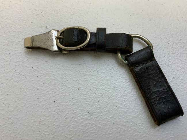 WWII GERMAN SS / NSKK DAGGER HANGER: WWII GERMAN SS / NSKK DAGGER HANGER . BLACK LEATHER WITH PLATED FITTINGS . ASSMANN MARKED CLIP WITH RZM M5/8 STAMP. LEATHER STRAP STAMPED L2/371/41. VERY GOOD CONDITION .