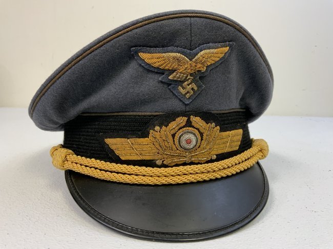 WWII GERMAN LUFTWAFFE GENERAL OFFICER VISOR HAT CAP - NAMED: WWII GERMAN LUFTWAFFE GENERAL OFFICER VISOR HAT CAP . NICE EXAMPLE! NAMED BUT ITS HARD TO READ THE NAME. NICE GOLD WIRE EMBROIDERED INSIGNIA. EAGLE APPEARS TO BE A REPLACEMENT. GREEN COLOR UNDER VISOR