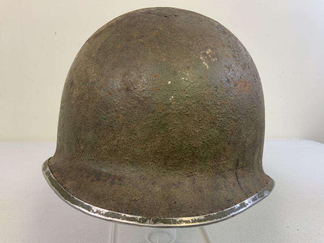 WWII US M1 FIXED BALE STEEL HELMET: WWII US M1 FIXED BALE STEEL HELMET. SHOWS ITS AGE WITH SOME DENTS AND CORROSION. STAINLESS STEEL RIM WITH FRONT SEAM.