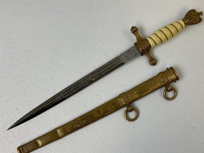 WWII GERMAN NAVY KRIEGSMARINE OFFICERS DAGGER EICKHORN: WWII GERMAN NAVY KRIEGSMARINE OFFICERS DAGGER BY EICKHORN . NICE OVERALL CONDITION WITH BRIGHT ETCHED BLADE . NICE BRASS FITTINGS . WHITE CELULOID COVERED GRIP . DENTS TO SCABBARD