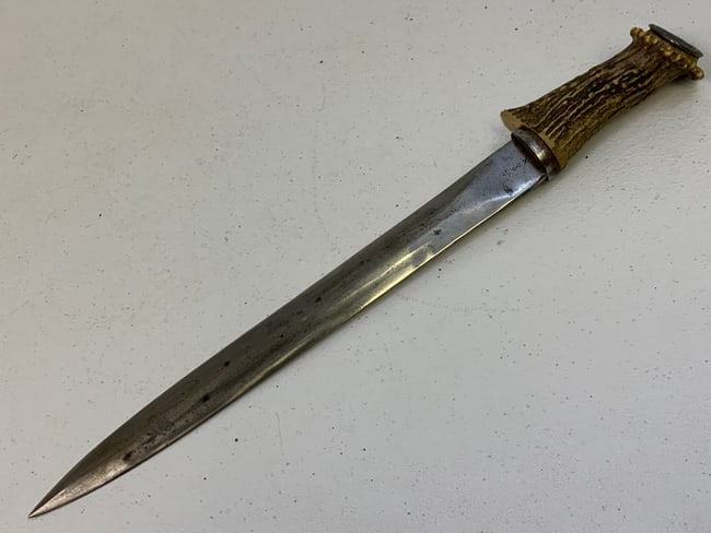 VINTAGE SCOTTISH DIRK MADE FROM OLD BAYONET BLADE STAG GRIP WITH COIN: VINTAGE SCOTTISH DIRK MADE FROM OLD BAYONET BLADE STAG GRIP WITH COIN ATTACHED TO THE TOP OF THE GIP. WWI ERA UK BAYONET BLADE . SHARPENED AND SHAPED INTO A DIRK BLADE . 16" LONG WITH 12" LONG BLADE. 