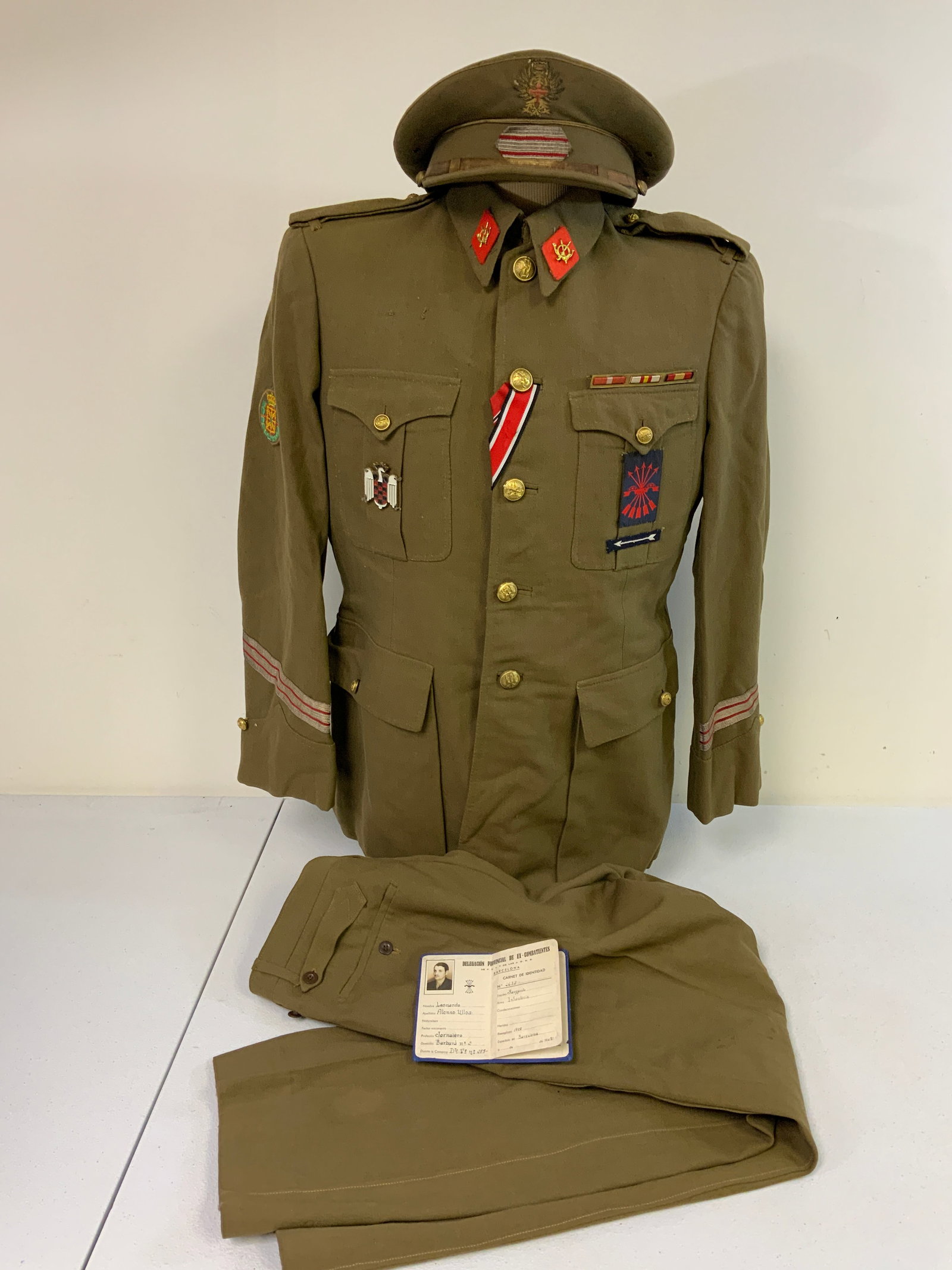 WWII SPANISH FASCIST OFFICERS UNIFORM TUNIC WITH PANTS AND HAT WITH ID DOCUMENT: WWII SPANISH FASCIST OFFICERS UNIFORM TUNIC WITH PANTS AND HAT WITH ID DOCUMENT. VERY NICE CONDITION RARE TO FIND UNIFORM. RUSSIAN FRONT AND GERMAN IRON CROSS BUTTON HOLE RIBBONS . AWARD BAR AND PATCH
