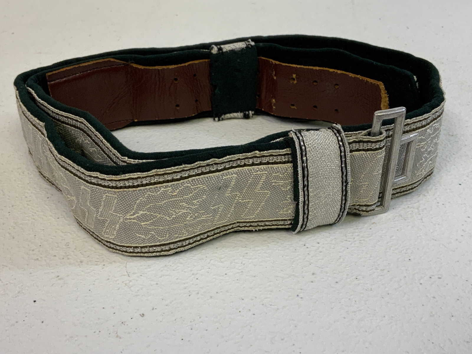 THIRD REICH GERMAN SS OFFICER DRESS BROCADE BELT: THIRD REICH GERMAN SS OFFICER DRESS BROCADE BELT . WELL WORN BUT STILL GOOD CONDITION BELT WITH GREEN WOOL BACKING. BOTH KEEPERS ARE PRESENT.RARE .