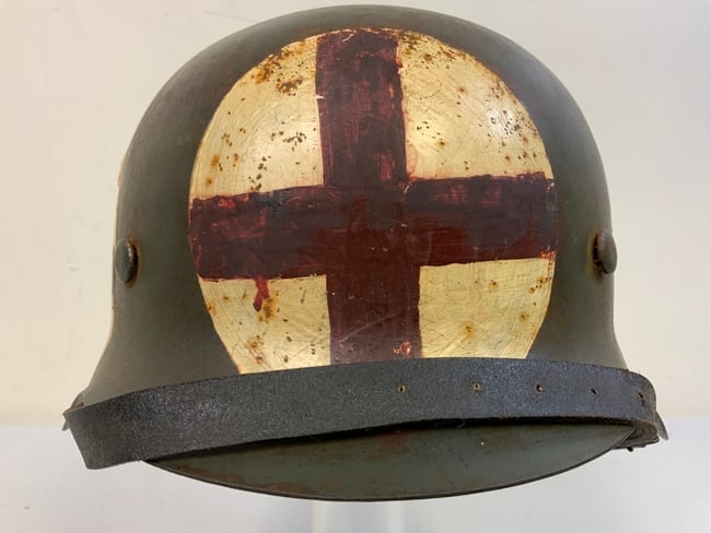 WWII GERMAN M42 HELMET WITH MEDIC RED CROSS PAINTED EMBLEMS: WWII GERMAN M42 HELMET WITH MEDIC RED CROSS PAINTED SHIELDS . VERY GOOD CONDITION OVERALL. CKL 62 AND NUMBER STAMPED ON THE BACK RIM . VERY GOOD LINER. GREAT DISPLAY HELMET .