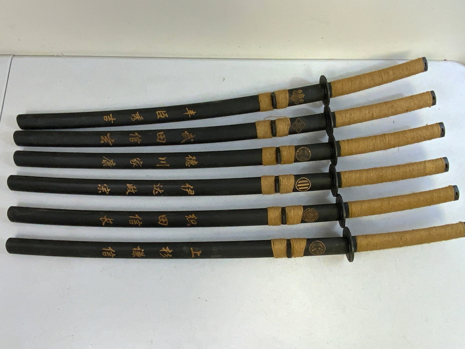 LOT OF 6 JAPANESE SAMURAI FAMILY CRESTS KAMON DECORATED DISPLAY SWORDS: LOT OF 6 JAPANESE SAMURAI FAMILY CRESTS KAMON DECORATED DISPLAY SWORDS . GREAT DISPLAY DECORATING SWORDS. 40" LONG. 25" LONG BLADES.