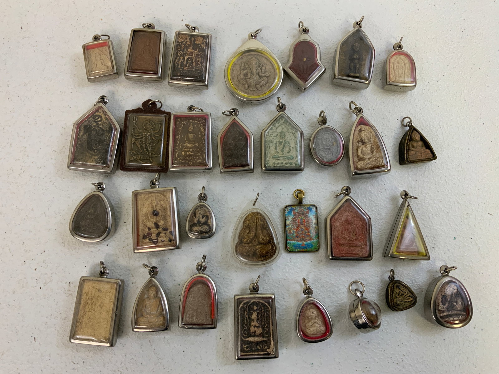 ANTIQUE THAILAND BUDDHIST AMULETS 1700 TO 1920: ANTIQUE THAILAND BUDDHIST AMULETS 1700 TO 1920 , VARIOUS AGES. ALL ARE IN SMALL PROTECTIVE TRANSPARENT CASES. LARGE LOT. FROM DR. PAUL D LYNN COLLECTION.