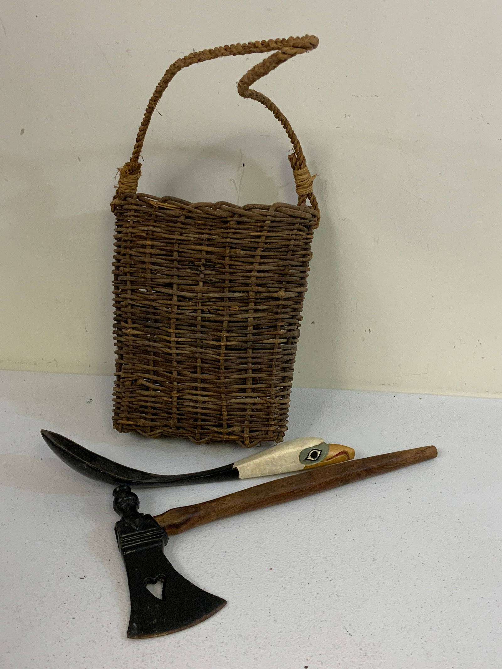 NATIVE AMERICAN BRITISH COLUMBIA HAIDA TRIBE ANTIQUES LOT: NATIVE AMERICAN BRITISH COLUMBIA HAIDA TRIBE ANTIQUES LOT. WOVEN BASKET WITH SHOULDER STRAP C.1800 9 12" LONG , TOMAHAWK PIPE C.1900 13" LONG AND FEAST SPOON C.1900 12" LONG. FROM DR. PAUL LYNN COLLEC