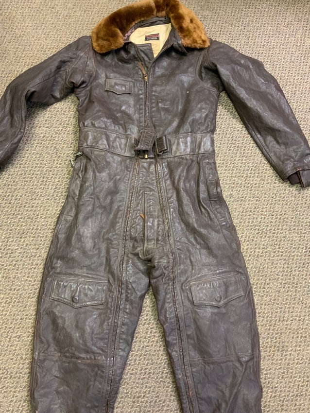 WWII US NAVY HEATED LEATHER FLIGHT SUIT CFN-24: WWII US NAVY HEATED LEATHER FLIGHT SUIT CFN-24.MAKER MARKED BY COLVINEX. BROWN LEATHER . FUR COLLAR AND COTTON LINING .TEAR IN THE WAIST BELT. WIRE INSULATION TO THE HEATING REMOTE IN THE POCKET IS FL