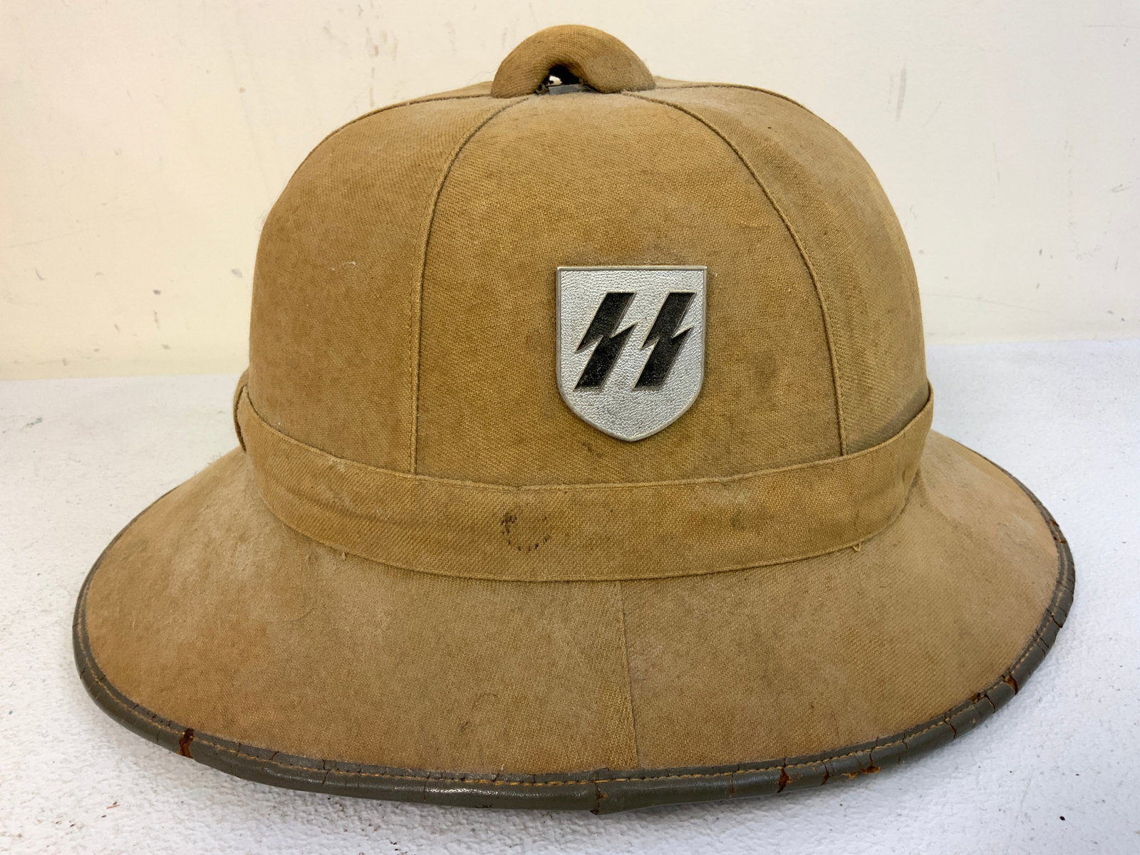 WWII GERMAN SS AFRIKA CORPS TROPICAL SUN PITH HELMET: WWII GERMAN SS AFRIKA CORPS TROPICAL SUN PITH HELMET. WELL USED CONDITION. TWO SS SHIELDS TO THE SIDES. SOLID HELMET AND QUITE RARE TO FIND.