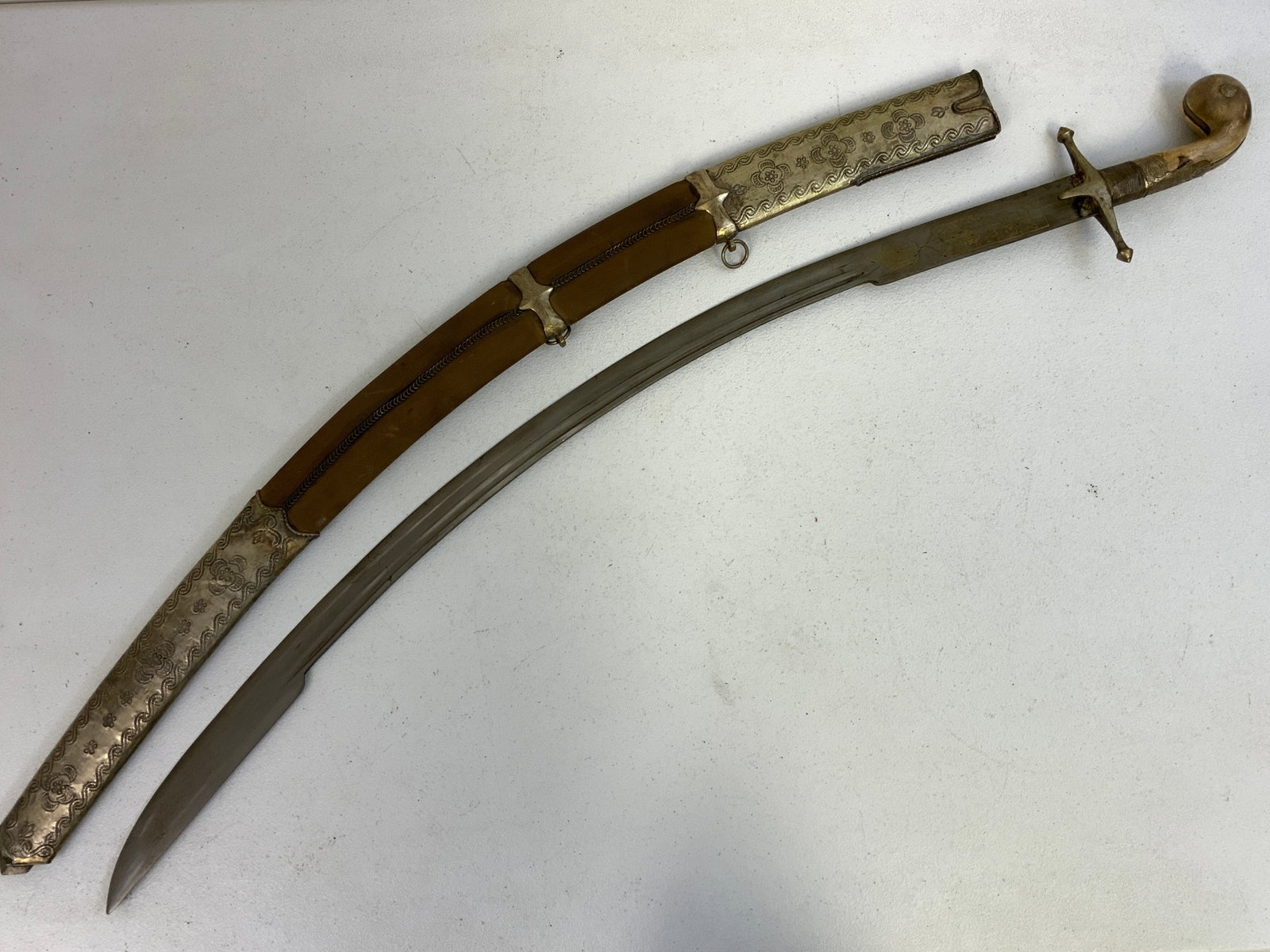TURKISH OTTOMAN ISLAMIC SHAMSHIR SWORD: TURKISH OTTOMAN ISLAMIC SHAMSHIR SWORD. MASSIVE SHARP CURVED BLADE WITH ISLAMIC DESIGNS IN GOLD.SILVER COLOR METAL DECORATED SCABBARD. NICE SWORD AND GREAT DECORATOR. 41" LONG WITH 34" CURVED BLADE.