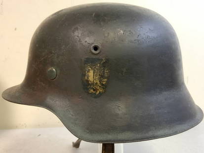 THIRD REICH GERMANY WWII ARMY M42 COMBAT HELMET: THIRD REICH GERMANY WWII ARMY M42 COMBAT HELMET. APEARS TO BE COMBAT CAMOUFLAGE PAINTED OVER ORIGINAL FINISH HELMET WITH MOST OF THE CAMOUFLAGE PAINT IS GONE FROM THE OUTSIDE EXPOSING DECALS. NICE LIN