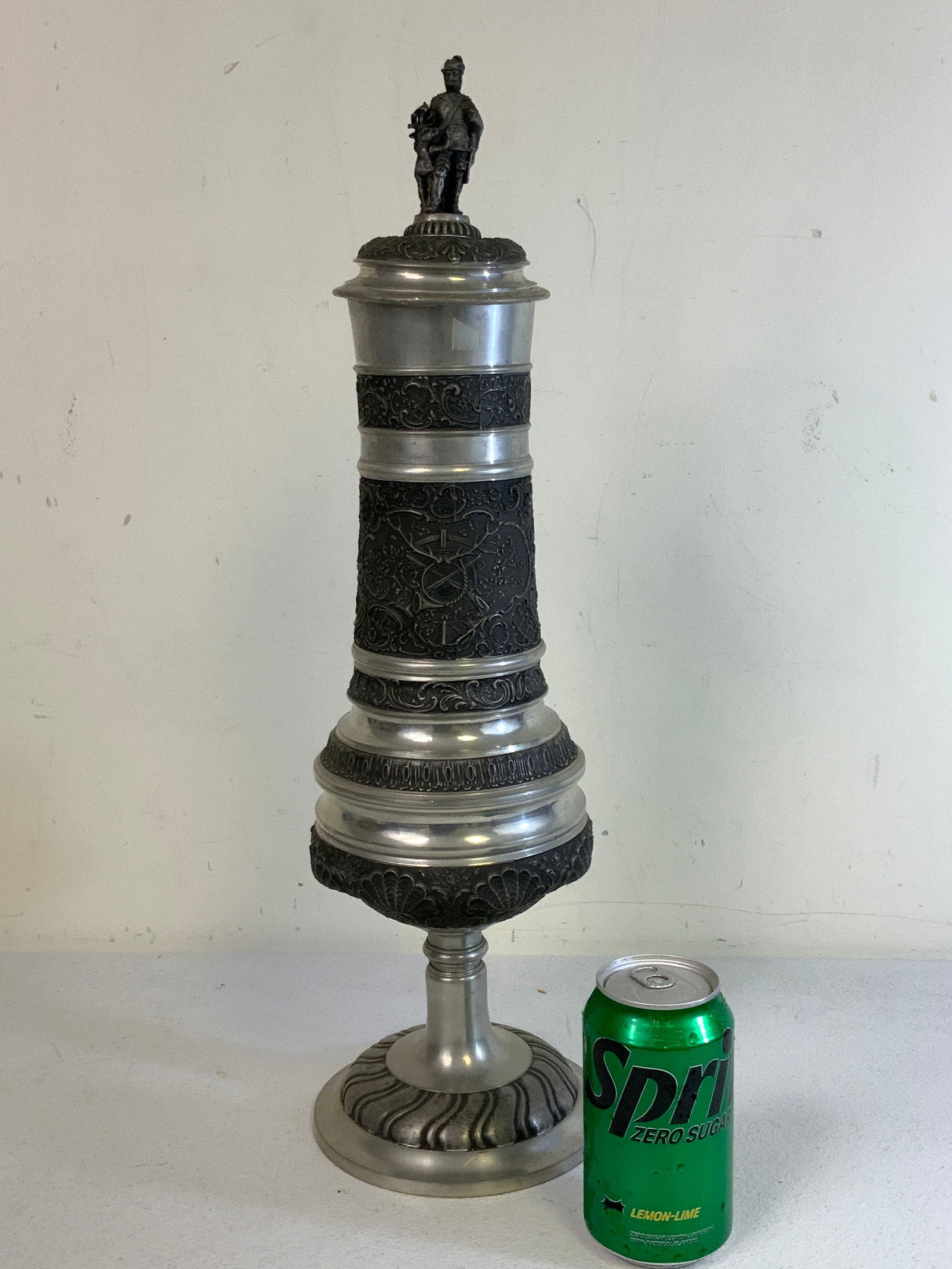 ANTIQUE HUGE GERMAN PEWTER HUNTING DECORATED BEER STEIN: ANTIQUE HUGE GERMAN PEWTER HUNTING DECORATED BEER STEIN . VERY LARGE SIZE. 21" TALL . LID WITH A HUNTER FIGURE HAS SOME DENTS. VERY RARE AND UNIQUE.