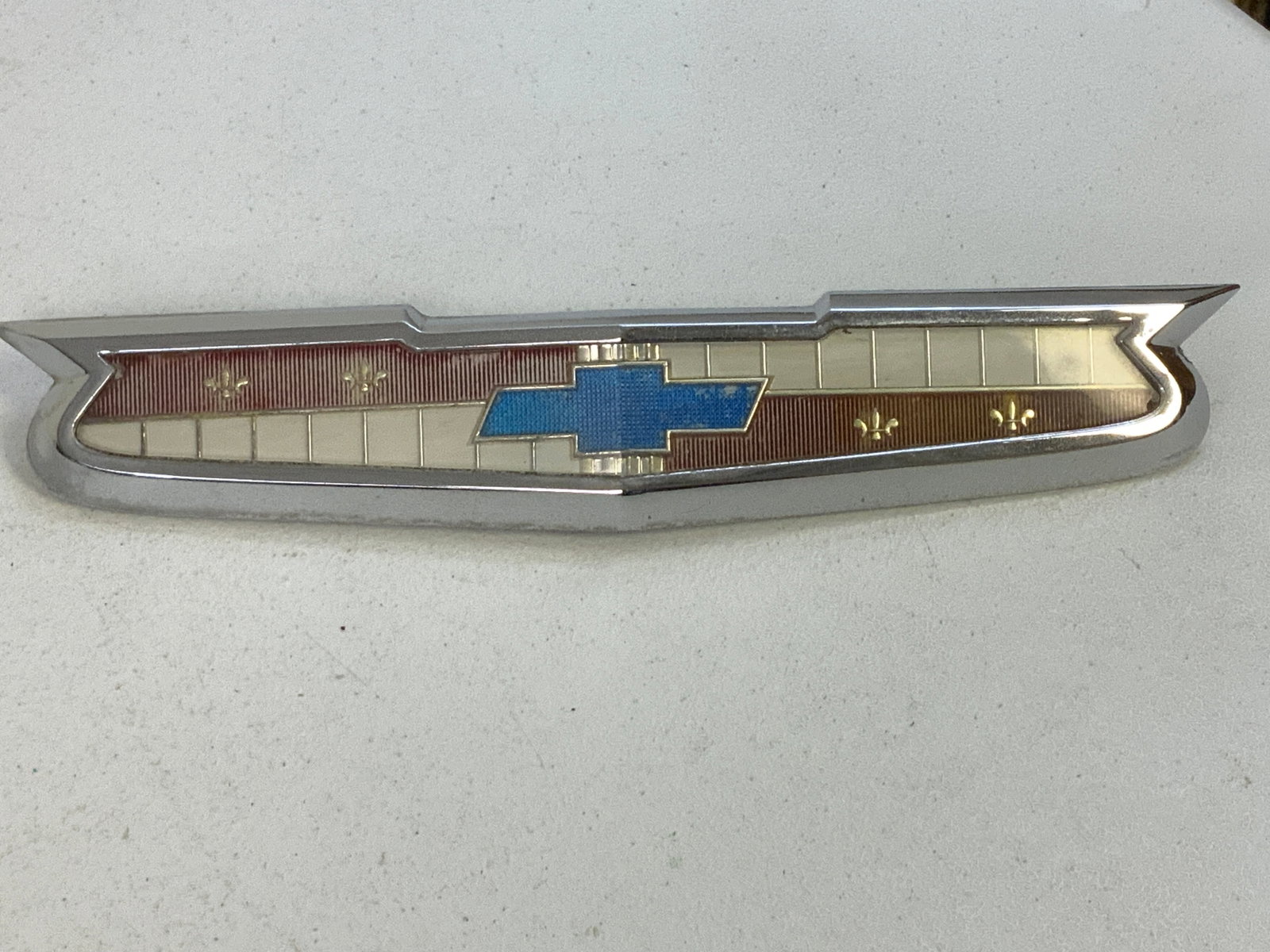 1956-58 CHEVY IMPALA BELAIR BISCANE HOOD EMBLEM ASSEMBLY: 1956-58 CHEVY IMPALA BELAIR BISCANE HOOD EMBLEM ASSEMBLY . GOOD CONDITION. CAME FROM 1958 CHEVY BISCANE 2 DOOR . 13 1/2 LONG . 2 1/2" WIDE.