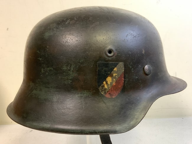 THIRD REICH GERMANY WWII ARMY M42 COMBAT HELMET: THIRD REICH GERMANY WWII ARMY M42 COMBAT HELMET. APEARS TO BE COMBAT CAMOUFLAGE PAINTED OVER ORIGINAL FINISH HELMET WITH MOST OF THE CAMOUFLAGE PAINT IS GONE FROM THE OUTSIDE EXPOSING DECALS. NICE LIN