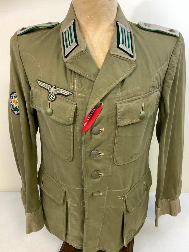 WWII GERMAN ARMY JAGER OFFICER SUMMER TUNIC: WWII GERMAN ARMY JAGER OFFICER SUMMER TUNIC. SOUTH FRONT USED. RUSSIAN FRONT RIBBON. WELL USED BUT STILL VERY GOOD CONDITION. BERLIN MAKER INK STAMPED. REMOVABLE BUTTONS. SOME FIELD REPAIR STITCHINGS.