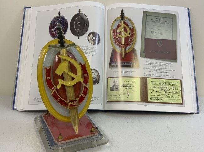 USSR DISTINQUISHED MVD WORKER DESK ORNAMENT WITH BOOK BY R. PANDIS: USSR DISTINQUISHED MVD WORKER DESK ORNAMENT WITH BOOK BY R. PANDIS. TEXTBOOK EXAMPLE FROM THE FAMOUS "CHEKA" BOOK BY CDR. ROBERT S. PANDIS. MADE FROM COLORED PLASTIC GLASS. VERY NICE QUALITY. MOST LIK