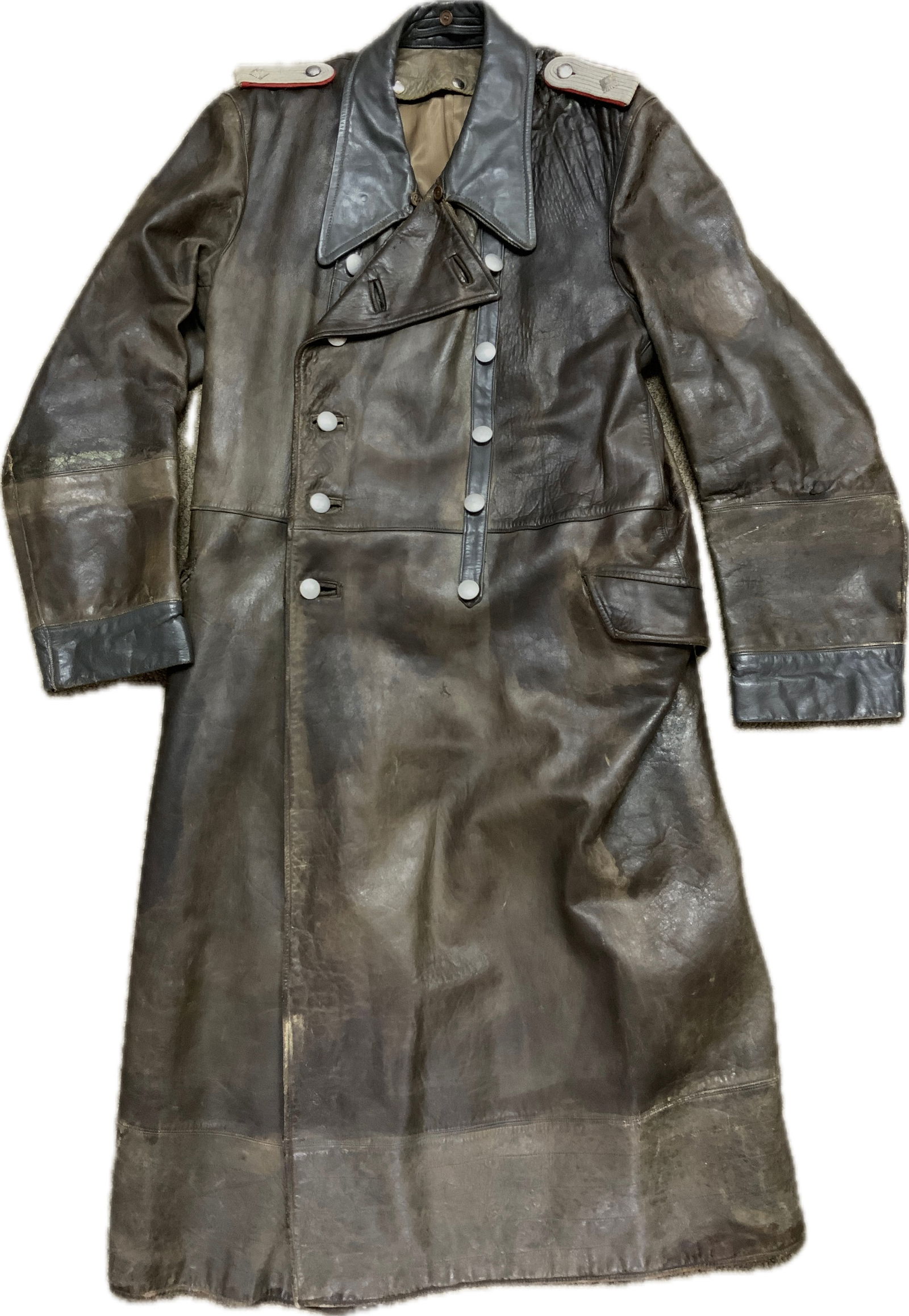 WWII GERMAN ARMY OFFICER LEATHER COAT: WWII GERMAN ARMY OFFICER LEATHER COAT. WELL WORN EXAMPLE WITH MUCH WEAR. GREAT HIGH QUALITY OFFICERS LEATHER WITH SOME REPAIRS AND PERIOD ALTERATIONS. RED PIPED SHOULDER BOARDS FOR ARTILLERY. VERY NIC