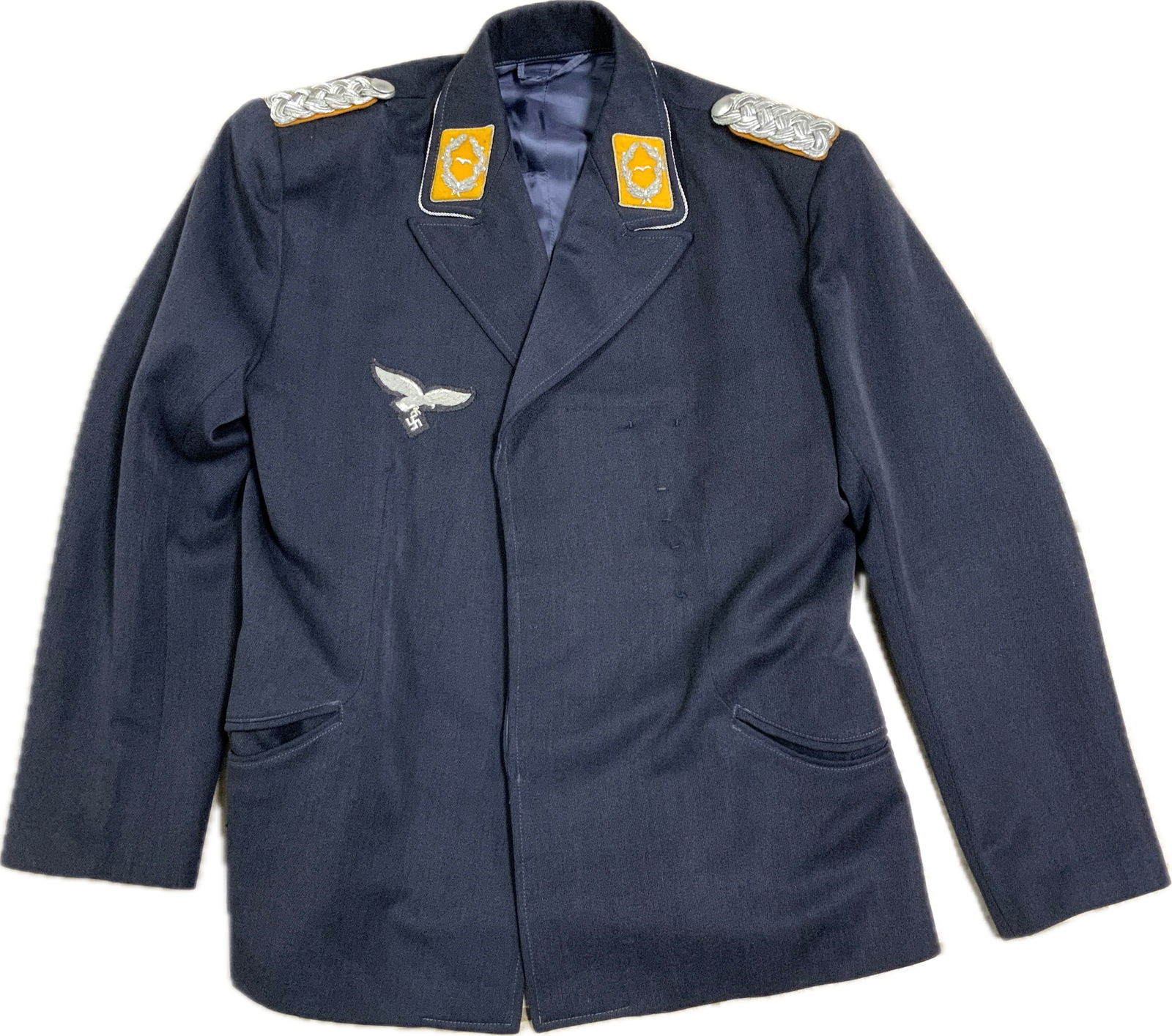 WWII GERMAN LUFTWAFFE FLIGHT OFFICER UNIFORM JACKET: WWII GERMAN LUFTWAFFE FLIGHT OFFICER UNIFORM JACKET. VERY NICE AND CLEAN EXAMPLE. LARGE SIZE. LUFTWAFFE BLUE LIGHT WOOD MATERIAL WITH SILK TYPE FABRIC LINING. STRAP WITH LOOP FOR A DAGGER. NICE JACKET