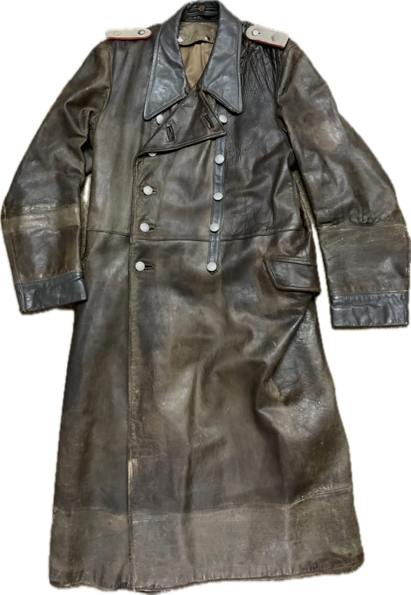WWII GERMAN ARMY OFFICERS LEATHER COAT: WWII GERMAN ARMY OFFICER LEATHER COAT. WELL WORN EXAMPLE WITH MUCH WEAR. GREAT HIGH QUALITY OFFICERS LEATHER WITH SOME REPAIRS AND PERIOD ALTERATIONS. RED PIPED SHOULDER BOARDS FOR ARTILLERY. VERY NIC