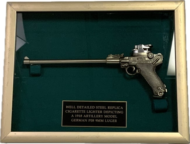 WELL DETAILED STEEL REPLICA P08 ARTILLERY LUGER CIGARETTE LIGHTER FRAMED: WELL DETAILED STEEL REPLICA CIGARETTE LIGHTER DEPICTIING A 1918 ARTILLERY MODEL GERMAN P08 LUGER. FRAMED IN 14" X 11" FRAME. THE GUN IS 11" LONG.