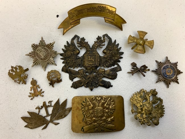 IMPERIAL RUSSIAN BRASS INSIGNIA LOT AND BELT BUCKLE: IMPERIAL RUSSIAN BRASS INSIGNIA LOT. NICE LOT OF MOSTLY HEADGEAR INSIGNIA AND BRASS BELT BUCKLE.RARE.