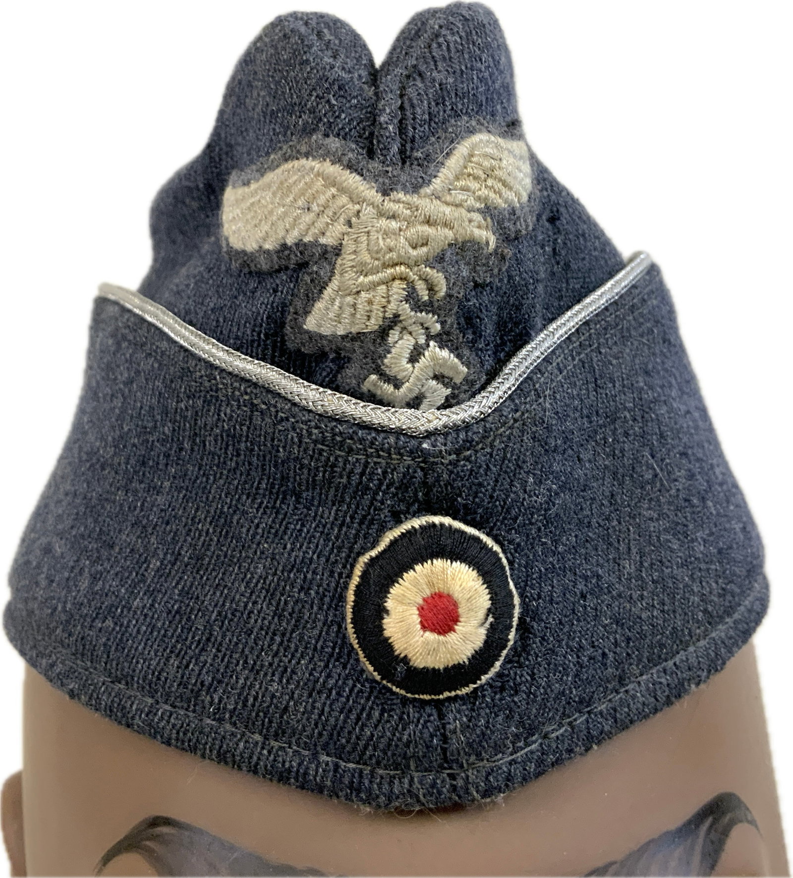 WWII GERMAN LUFTWAFFE OFFICERS FIELD CAP: WWII GERMAN LUFTWAFFE OFFICERS FIELD CAP.WELL WORN EXAMPLE WITH SOME MOTH DAMAGE ESPECIALLY TO THE LEFT SIDE. NICE INSIGNIA. SIZE 54 STAMPED.