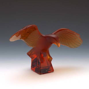 LALIQUE AMBER FROSTED CRYSTAL EAGLE ART GLASS SCULPTURE: LALIQUE AMBER FROSTED CRYSTAL EAGLE ART GLASS SCULPTURE Molded and frosted glass figurine of an amber colored eagle landing on a polished plinth. With four felt feet, marked underneath, etched on the