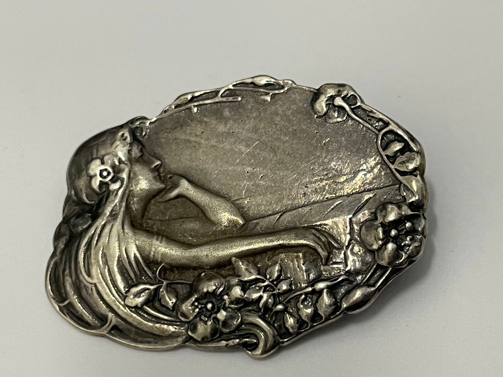 STERLING SILVER ART NOUVEAU PONDERING YOUNG GIRL BROOCH w/ FLOWERS RAYS OF LIGHT An Impressive: STERLING SILVER ART NOUVEAU PONDERING YOUNG GIRL BROOCH w/ FLOWERS RAYS OF LIGHT An Impressive Sterling Silver Art Nouveau Pondering Young Girl Brooch, circa 1910 marked '925' shrouded with flower fol