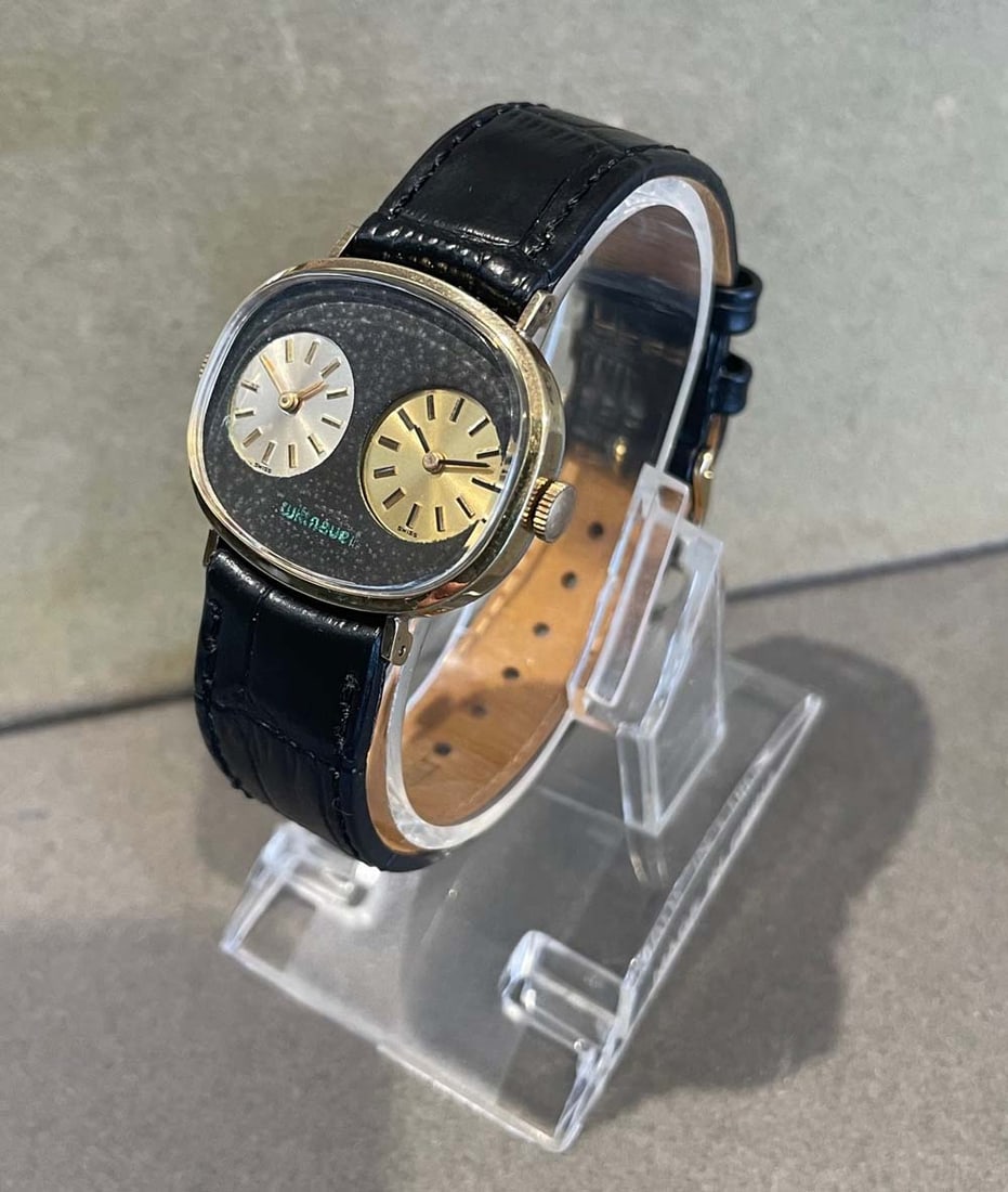 WITTNAUER DUAL TIME MANUAL WIND TRAVELERS WRIST WATCH, CIRCA 1975, JUST SERVICED With Swiss: WITTNAUER DUAL TIME MANUAL WIND TRAVELERS WRIST WATCH, CIRCA 1975, JUST SERVICEDWith Swiss mechanical movements, silver and champagne dials, 27x32mm. gold tone case, replacement black leather strap ba