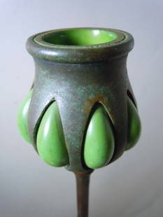 TIFFANY STUDIOS NY BRONZE FAVRILE GLASS CANDLESTICK   A Tiffany Studios Patinated Bronze and: TIFFANY STUDIOS NY BRONZE FAVRILE GLASS CANDLESTICKA Tiffany Studios Patinated Bronze and Favrile Glass Candlestick, having a bulbous candle cup (bobeche) with blown out green glass, above the slender