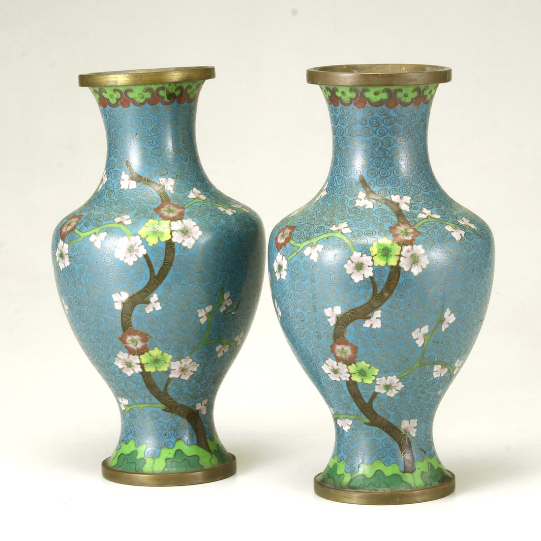 PAIR OF LATE QING DYNASTY (1644-1911), CHINESE CLOISONNE ENAMEL VASES Decorated in mirror on a: PAIR OF LATE QING DYNASTY (1644-1911), CHINESE CLOISONNE ENAMEL VASES Decorated in mirror on a turquoise ground depicting flowering branches and cherry blossoms, accented by ruyi head border and shade