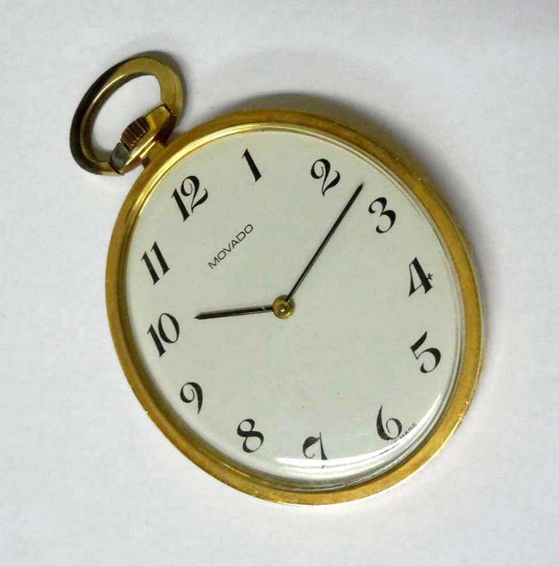 14K GOLD MOVADO ARABIC NUMERAL OVAL DIAL POCKET WATCH An outstanding vintage 20th Century Modern: 14K GOLD MOVADO ARABIC NUMERAL OVAL DIAL POCKET WATCH An outstanding vintage 20th Century Modern 14kt Gold Movado Arabic Numeral Oval Pocket Watch, with a mechanical Swiss movement, water resistant sn