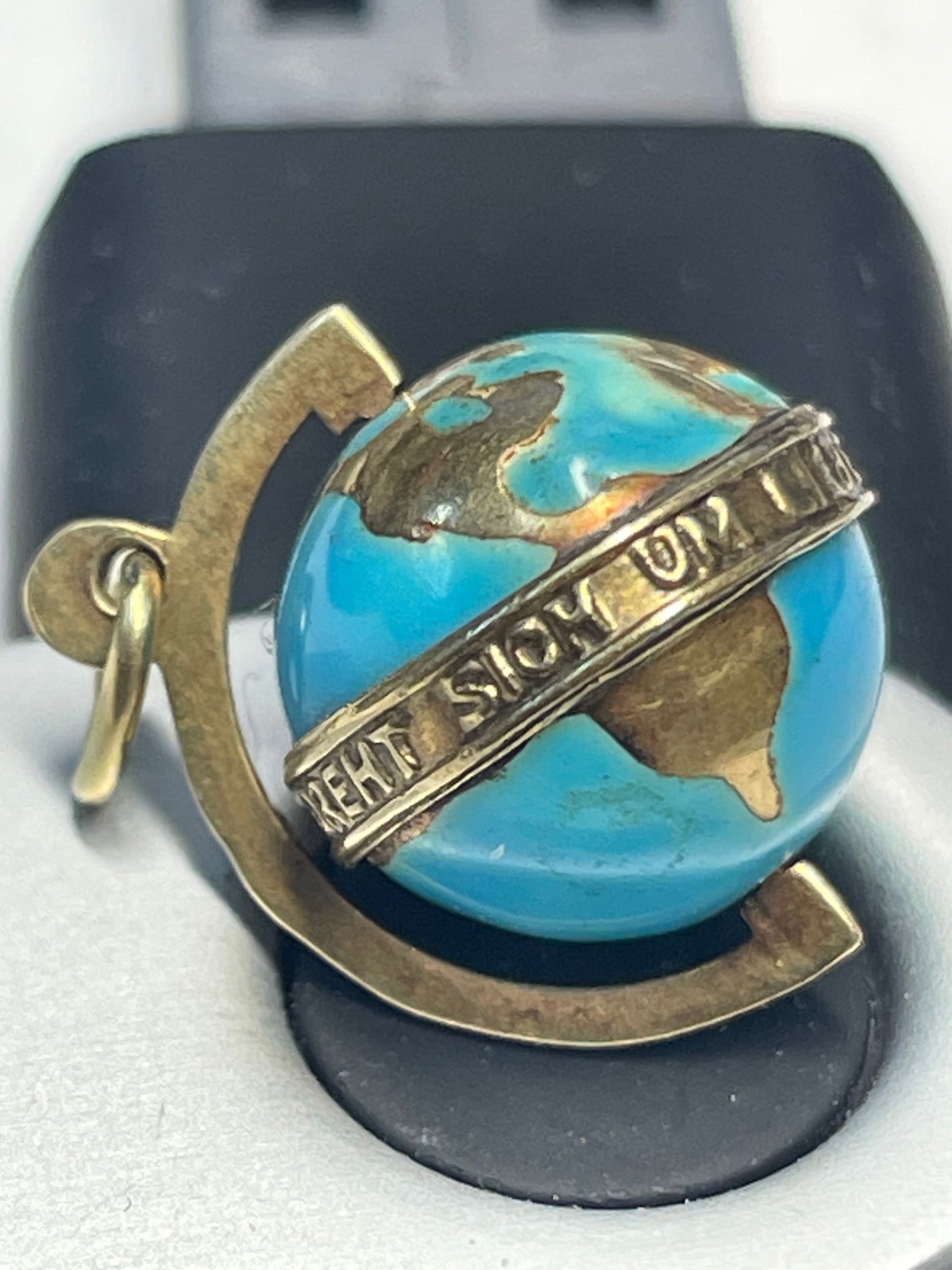 14K GOLD ENAMEL 3D SPINNING WORLD GLOBE EARTH DAY PENDANT Marked, ''585'' and reads, ''Die Ganze: 14K GOLD ENAMEL 3D SPINNING WORLD GLOBE EARTH DAY PENDANT Marked, ''585'' and reads, ''Die Ganze Welt Dreht Sich Um Liebe'' which in German: (The World's in Love) is a 1935 Austrian comedy film direct