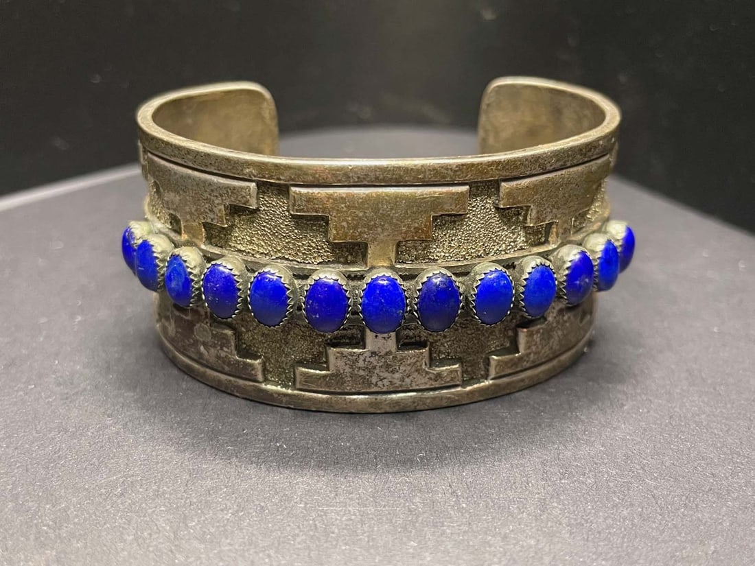 SILVER & LAPIS LAZULI RICK MARTINEZ NATIVE AMERICAN NAVAJO INDIAN WIDE CUFF BRACELET c. 1980: SILVER & LAPIS LAZULI RICK MARTINEZ NATIVE AMERICAN NAVAJO INDIAN WIDE CUFF BRACELET c. 1980 Crafted in sterling silver, and decorated in a geometric Navajo style set with oval shaped lapis lazuli ? a