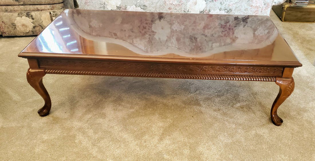 Queen Anne Style Carved Wood Coffee Table: Fine quality Queen Ann style carved wood rectangular coffee table with intricate pattern on border/sides of table and legs. Light scratch on surface.
