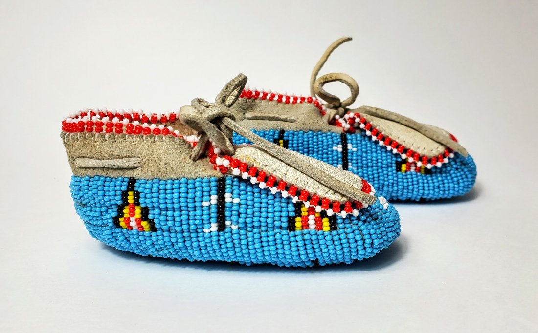 Native American Ceremonial Beaded Infant Moccasins: A pair of pristine Native American Ceremonial Beaded Moccasins. Made of soft kid leather with overall beading in turquoise with red, white, black, and yellow accents. Approximately 4.25\" long, 1.75\"