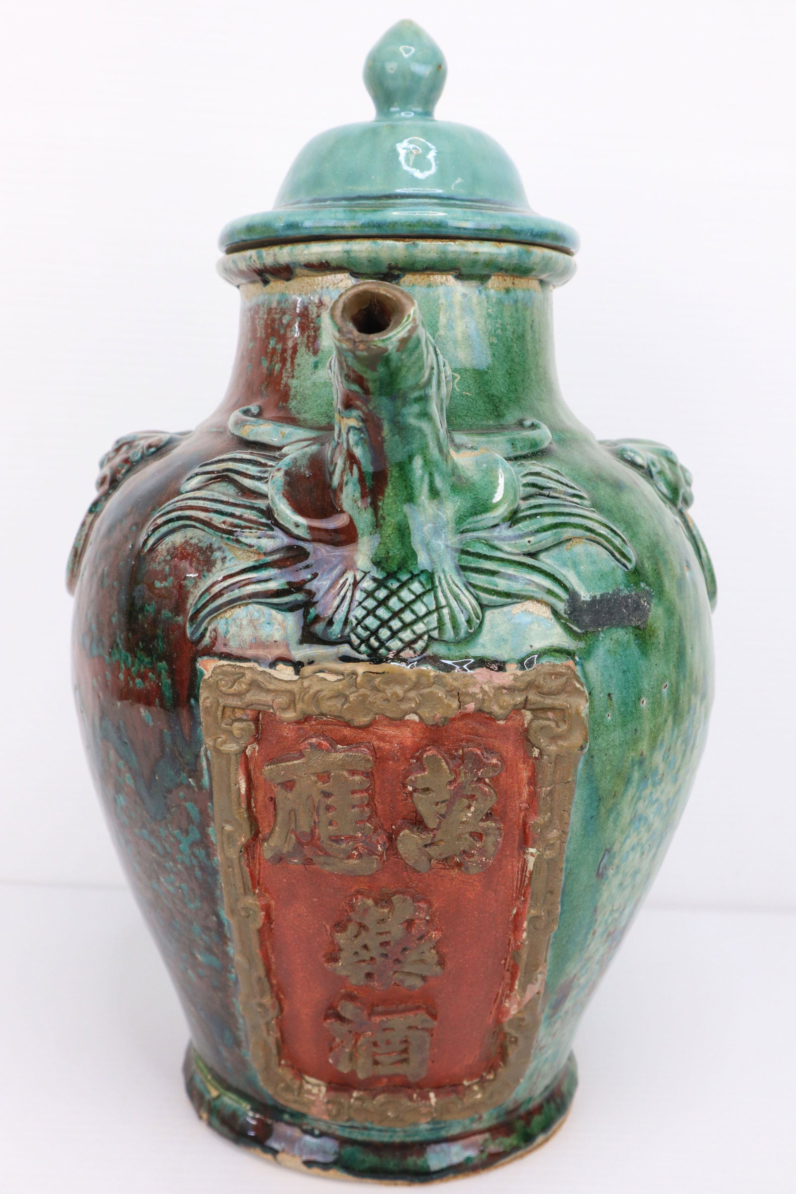 CHINESE STONEWARE RED AND GREEN GLAZED JUG, FOO DOG SPOUT AND MOTIF ON SIDE, WITH FINIAL LID: Chinese Stoneware Red-Green Glazed Jug, Foo dog Spout And Motif On Side, Finial Lid, 4 Character Mark Below Spout, 10X14X16.5", 13#
