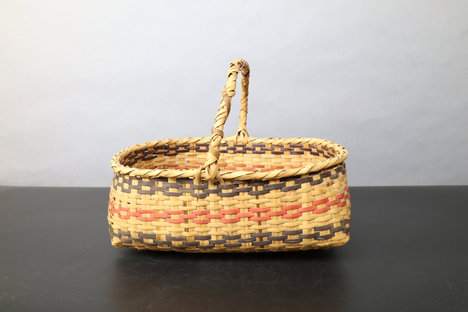 NATIVE AMERICAN CHOCTAW TRIBE SPLIT CANE WEAVE GATHERING BASKET, 13"L, 5.5"H, 9.75"H WITH HANDLE: DESCRIPTION: NATIVE AMERICAN CHOCTAW TRIBE SPLIT CANE WEAVE GATHERING BASKET, 13"L, 5.5"H, 9.75"H WITH HANDLE CONDITION: Please See Photos For Condition. Condition Is Commensurate With Age And Use. We