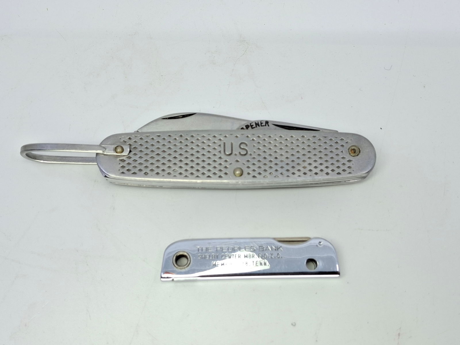 US ARMY UTILITY KNIFE, AND THE PEOPLE'S BANK ADV. KEYCHAIN KNIFE: DESCRIPTION: US ARMY UTILITY KNIFE, AND THE PEOPLE'S BANK ADV. KEYCHAIN KNIFE. CONDITION: Please See Photos For Condition. Condition Is Commensurate With Age And Use. We Aim To Take Additional Photos