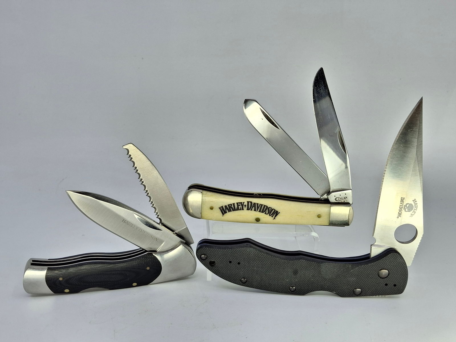 THREE HARLEY DAVIDSON FOLDING POCKET KNIVES, BONE HANDLE CASE XX 6254, AND STANDARD BLACK BENCH MADE: DESCRIPTION: THREE HARLEY DAVIDSON FOLDING POCKET KNIVES, BONE HANDLE CASE XX 6254, AND STANDARD BLACK BENCH MADE. CONDITION: Please See Photos For Condition. Condition Is Commensurate With Age And Us