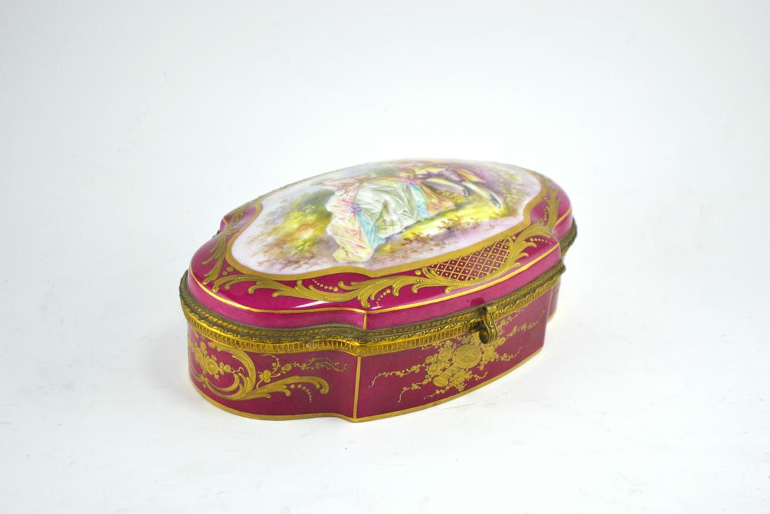 French porcelain box.: Caja en porcelana francesa color bordeaux decorada con detalles en oro y "escena galante" central pintada a mano. Medidas: alto 10 cm - ancho 25 cm - profundidad 17 cm.