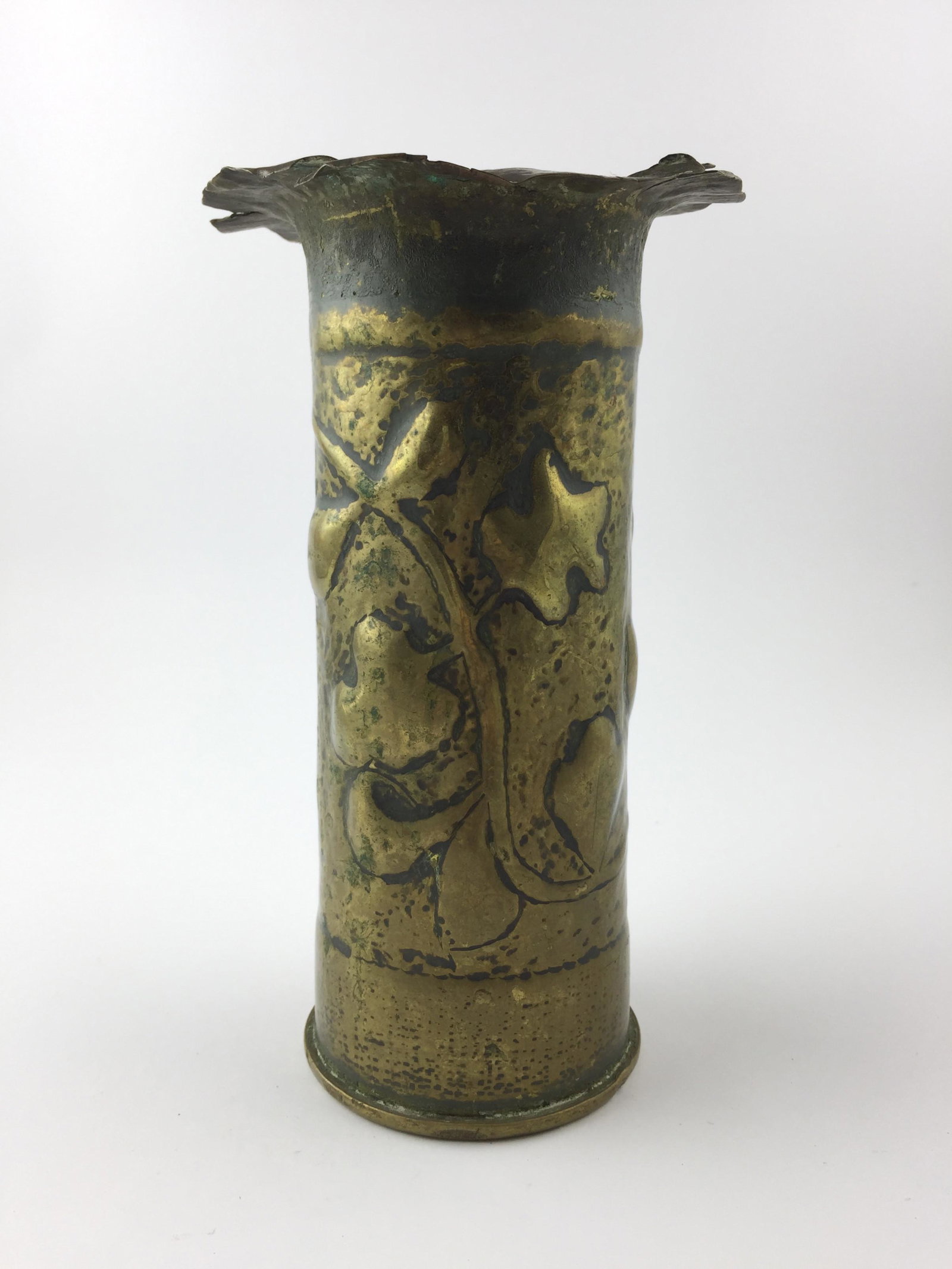 Trench Art on bronze cannon scabbard, embossed "Leaves": Arte de trinchera realizado sobre vaina de caÃ±Ã³n en bronce repujado "hojas", con iniciales "L.G.". Medidas: alto 21 cm - diÃ¡metro 8.5 cm.