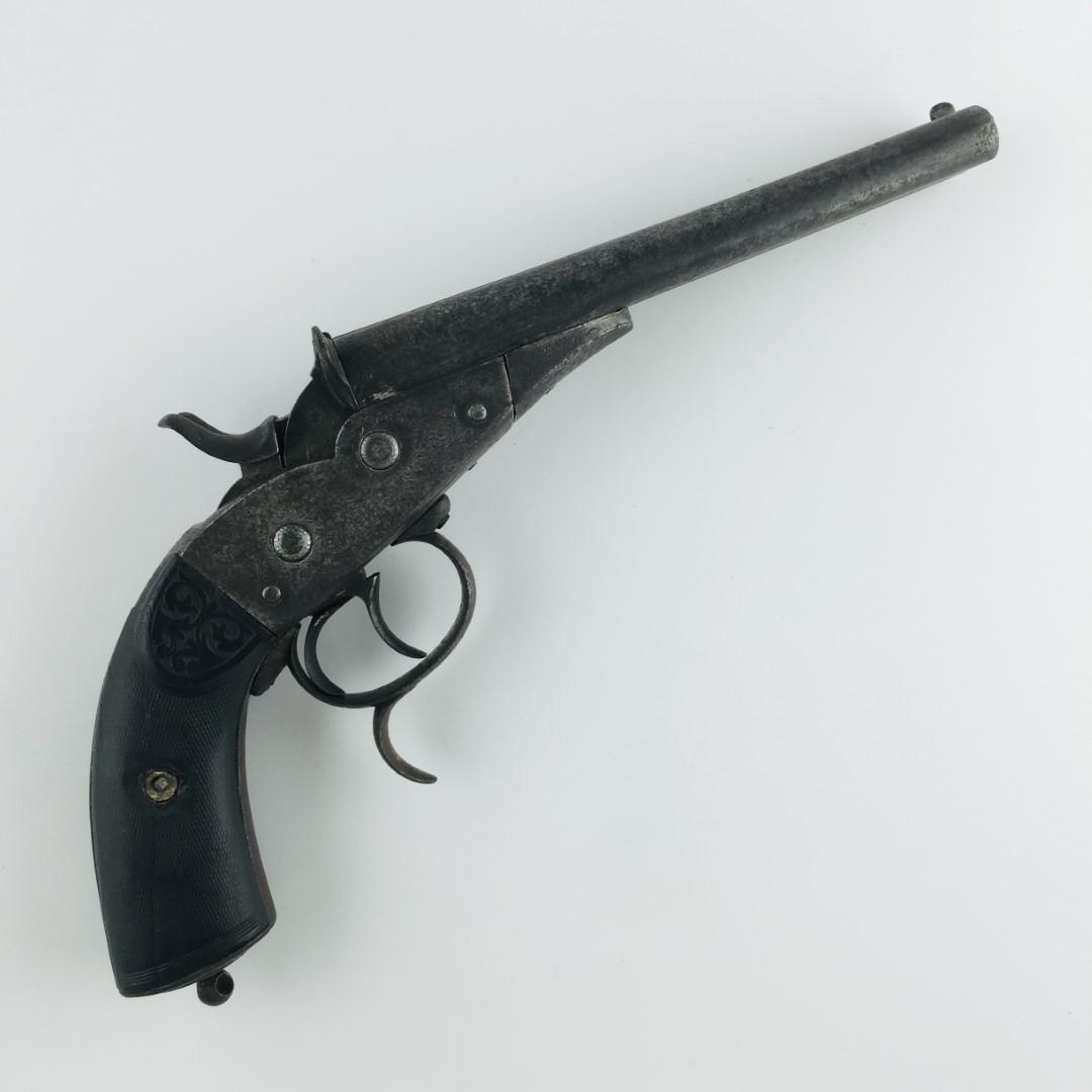Pistol: Belgian 12 mm Rolling Block pistol. Double barraled. Segmented wood handles. Gun brand "Sol" by Broqua & Scholberg. Two non-original screws. PLEASE CONTACT US BEFORE BIDDING ON A FIREARM SO THAT WE CA
