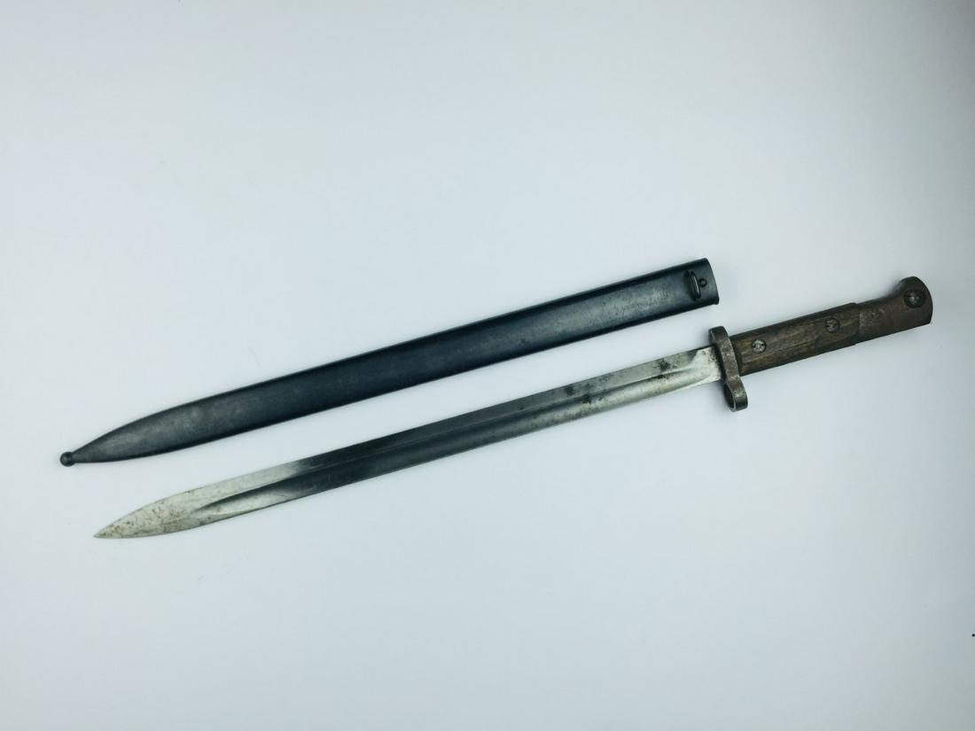 Bayonet: Long bayonet for Czechoslovakian Mauser, model 24 rifle. Wooden handle and blued metal scabbard. Total length 54.5 cm. Bayoneta larga para fusil Mauser checoslovaco modelo 24 de exportación. Cach