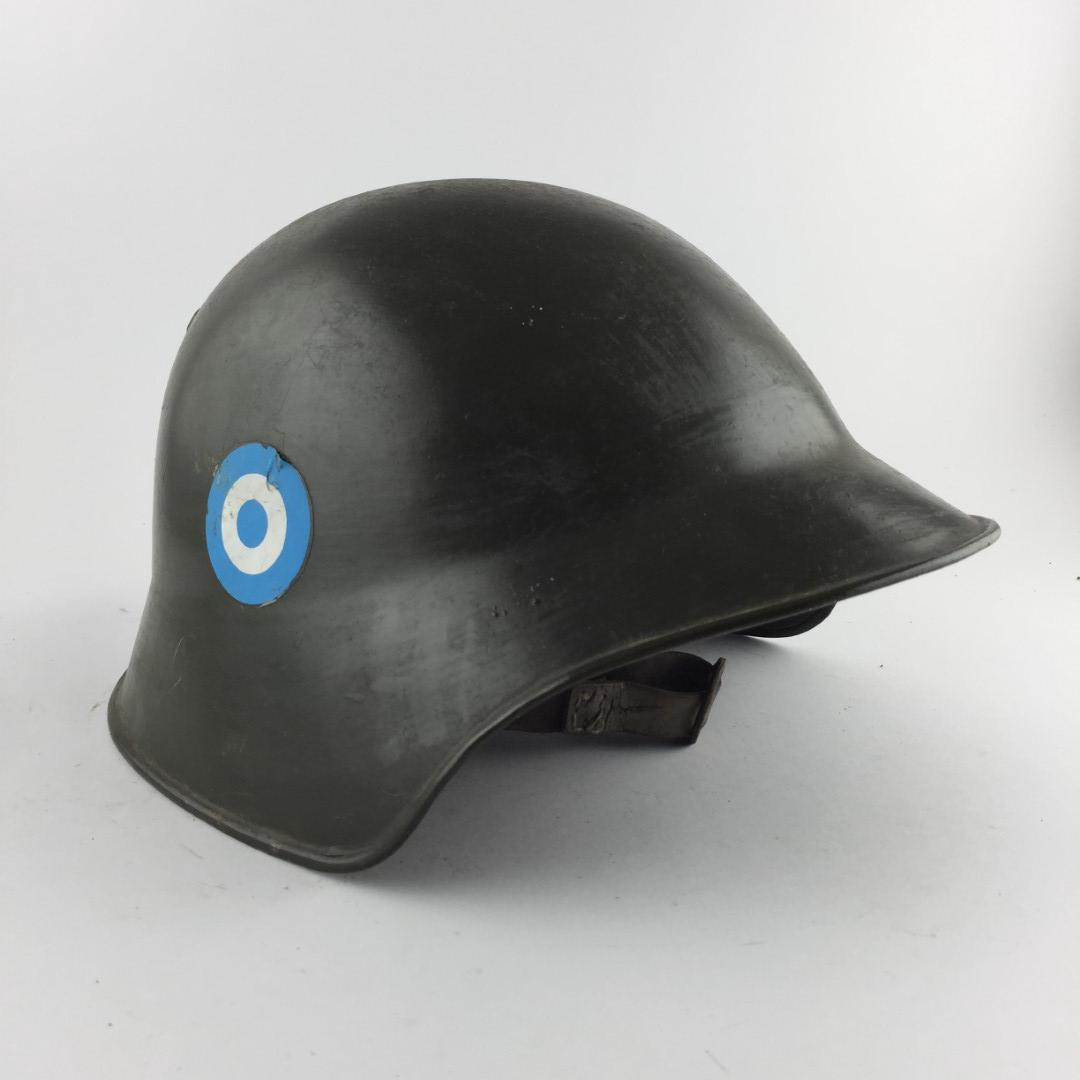 Helmet: Swiss-Argentinean helmet in green painted iron. Complete interior, with small damages. Casco suizo-argentino en hierro pintado color verde, con escarapela lateral argentina. Interior completo, con peq