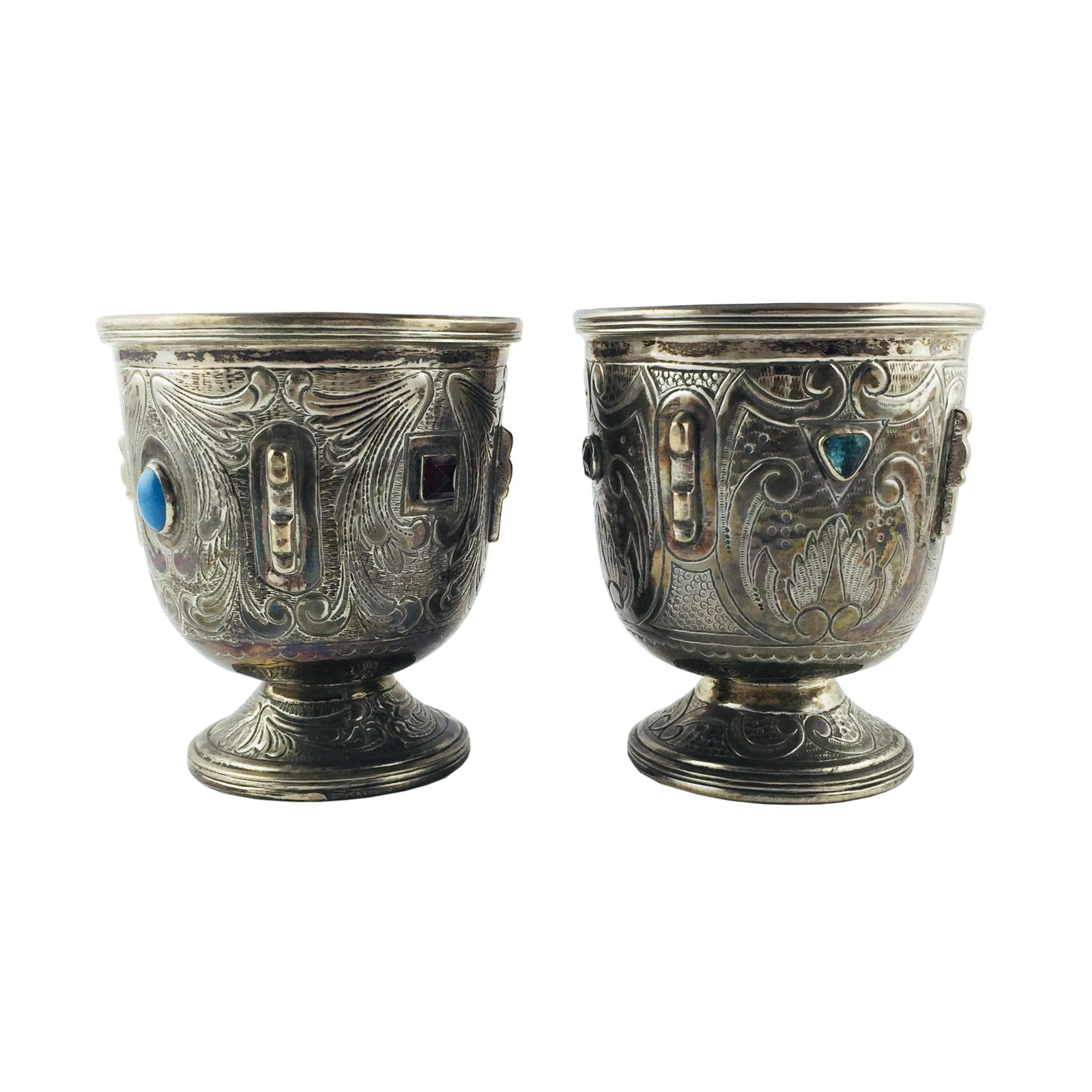 Pair of Spanish chalices in silver: Pair of Spanish chalices in silver, with chiselled "leaves", decorated with semi-precious stones. 13 x 11 cm. Gross weight 560 gr. Par de cálices españoles en plata cincelada "hojas", decora